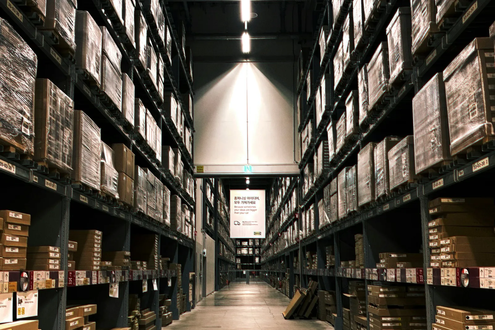 Allée d'entrepôt avec des rayonnages remplis de cartons
